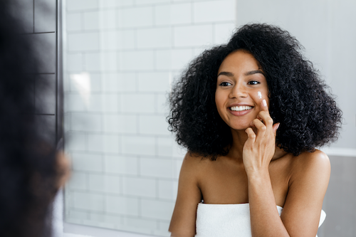 Girl applying CBD topical cream.