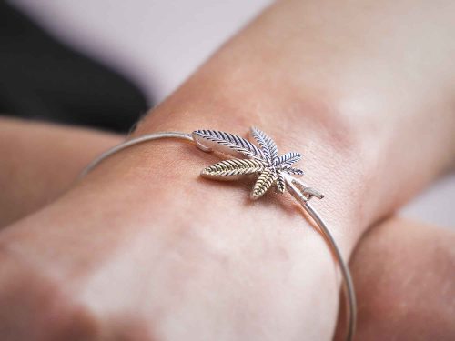 Model wearing silver marijuana leaf arm bracelet