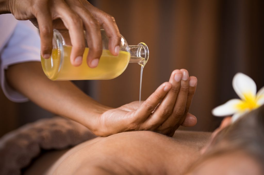 person adding cbd massage oil to their hand