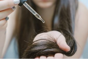 Women using CBD hair serum in her hair and scalp